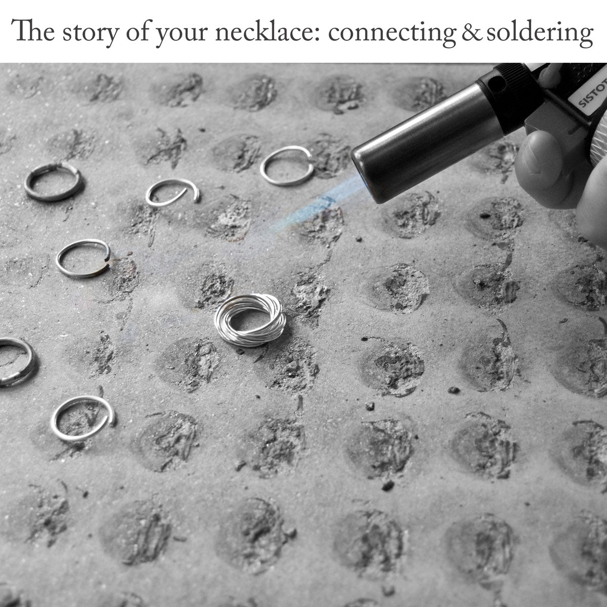 Close-up of an asbestos mat showing a jewellery-making process involving several thin rings being joined together using silver solder and a blow-torch, under the caption 'The story of your necklace: connecting and soldering'