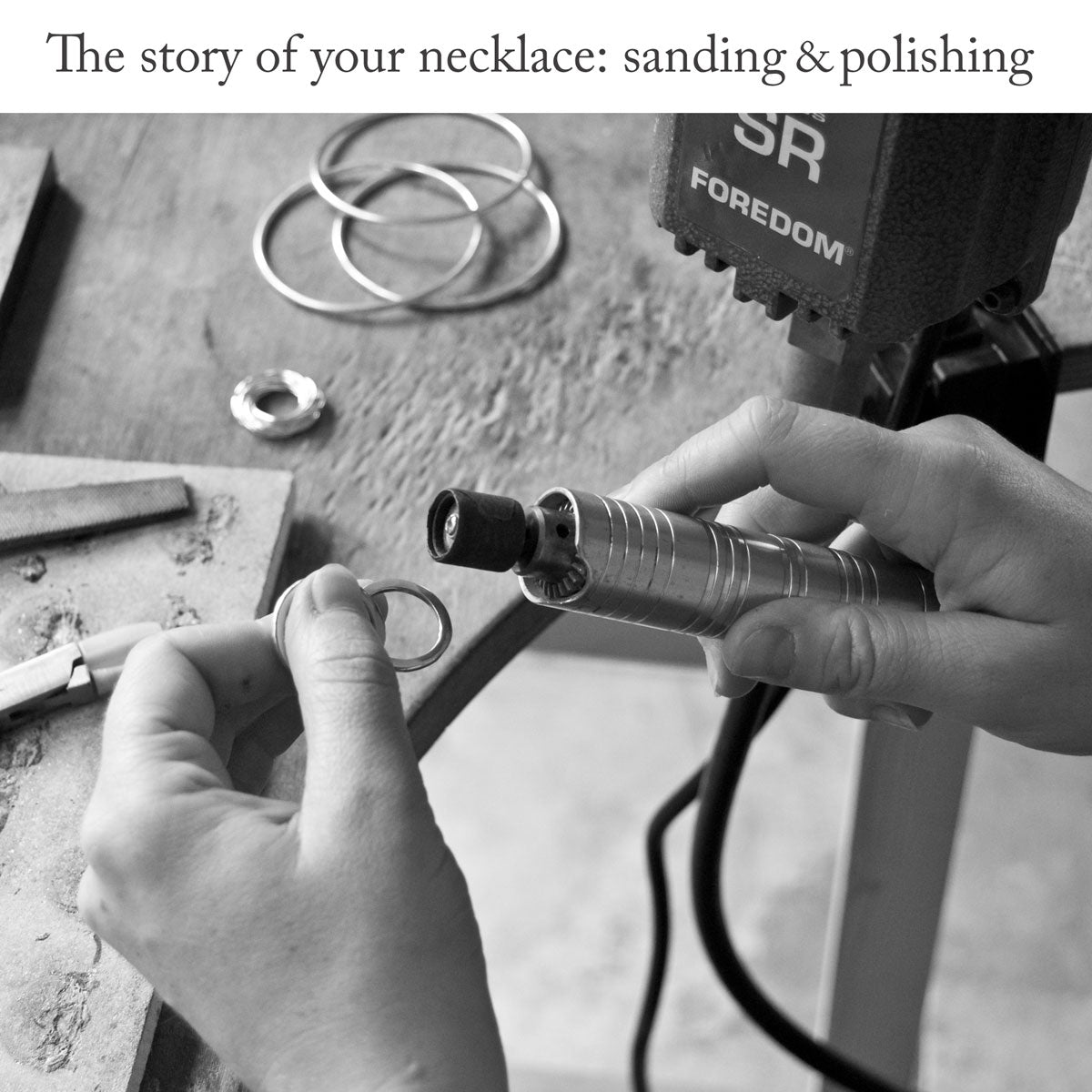 Jewellery maker sanding and polishing a ring with a Foredom tool over the surface of wooden work bench with the headline 'The story of your necklace: sanding and polishing'