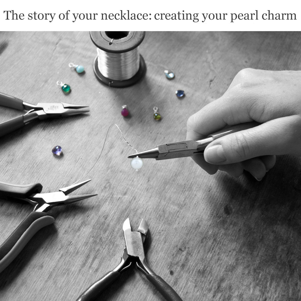 Handcrafting a pearl charm with jewellery-making tools and wire on the wooden surface of a work bench