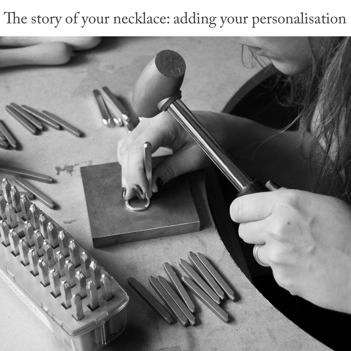 Close-up of women sitting at a jewellery bench using a metal-stamping block, brass hammer and a selection of metal stamps to apply letters to a sterling silver ring under the caption &#39;The story of your necklace: adding your personalisation&#39;
